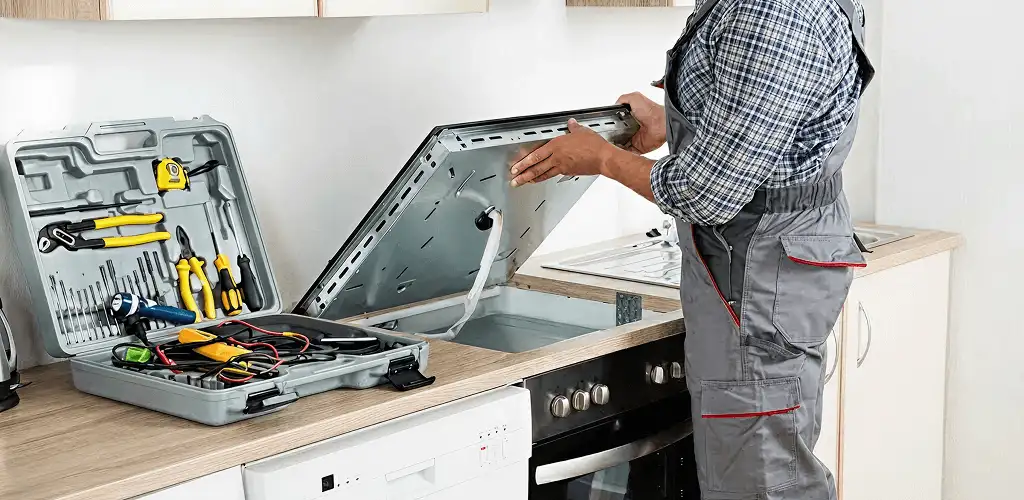 Handyman repairing a cooktop and checking wiring connections in Tucson, AZ