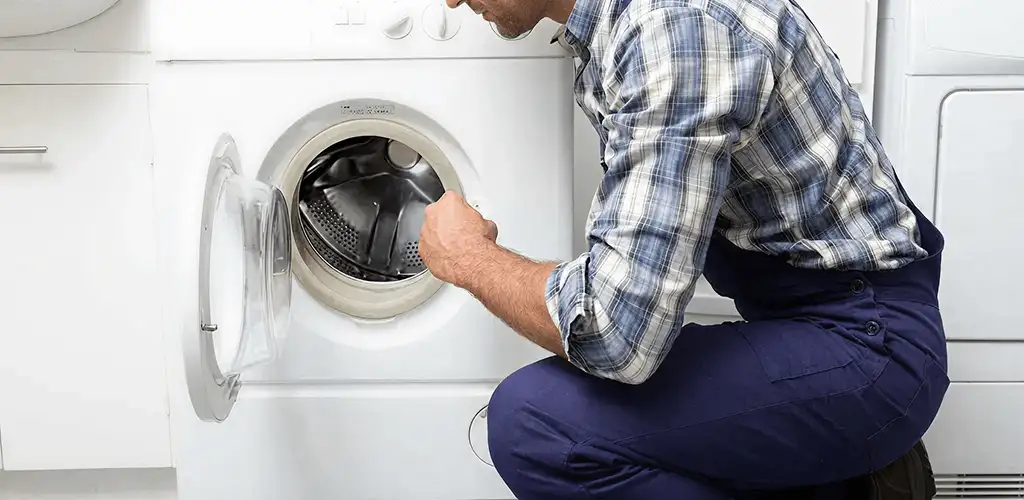 Handyman inspecting a dryer drum and internal parts for repair in Tucson, AZ