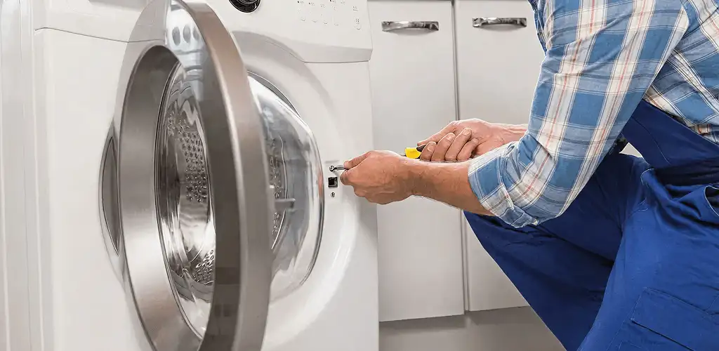 Handyman repairing a clothes dryer and checking electrical connections in Tucson, AZ