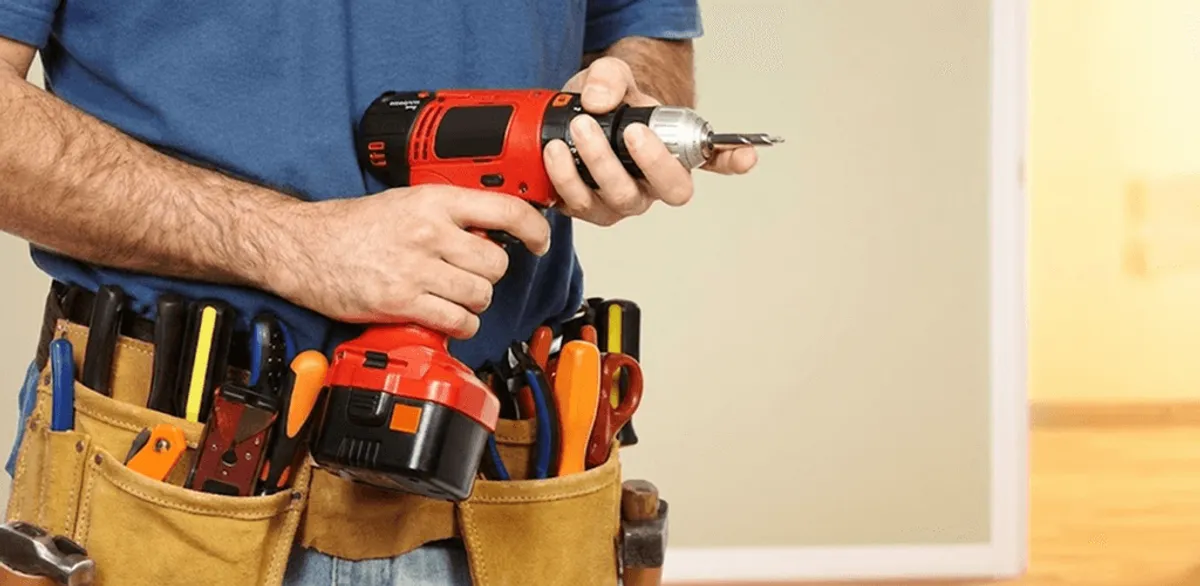 Handyman holding a power drill for home repairs and installations in Tucson, AZ