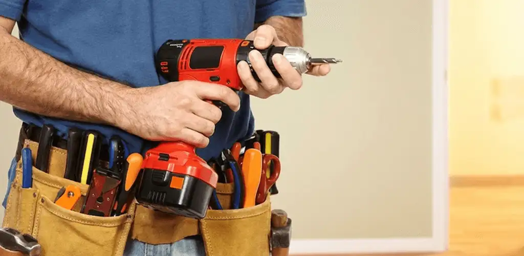 Handyman holding a power drill for home repairs and installations in Tucson, AZ