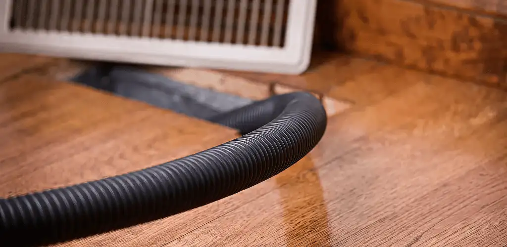 Air duct cleaning hose inserted into a floor vent for ductwork cleaning in Tucson, AZ